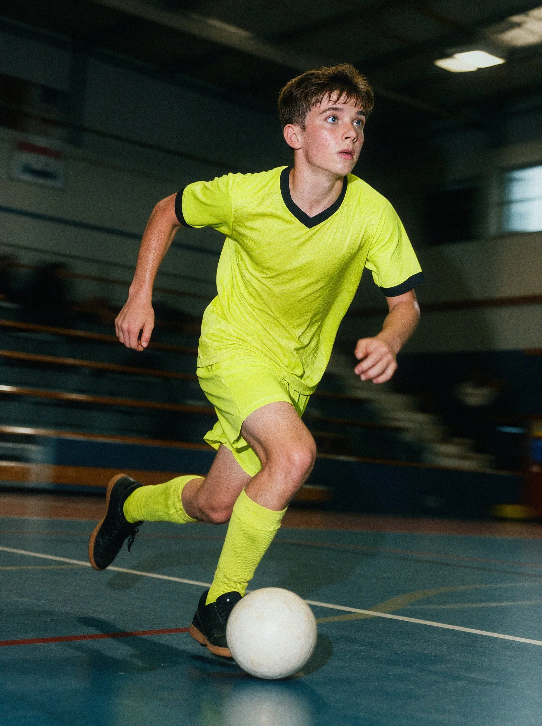Scorpions player sprinting with the ball across an indoor futsal court